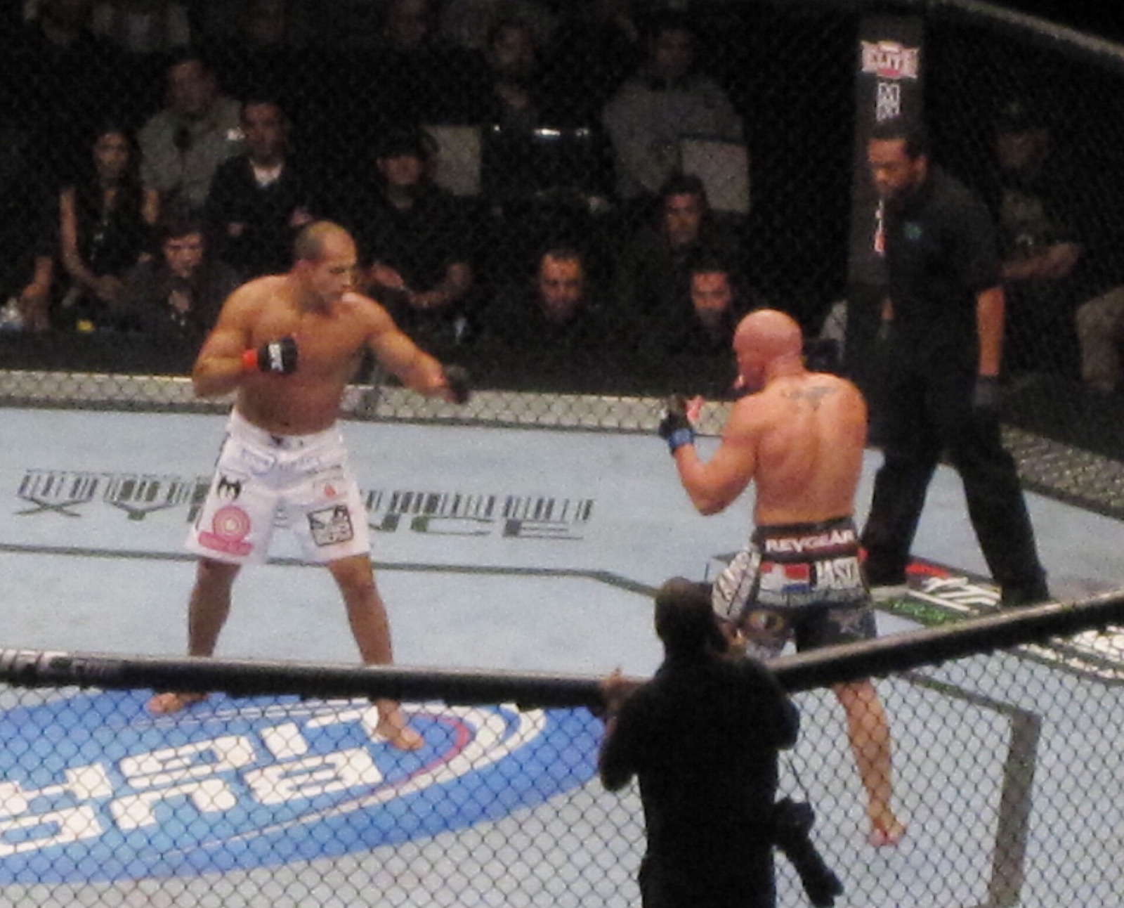 Two fighters trading in a packed arena